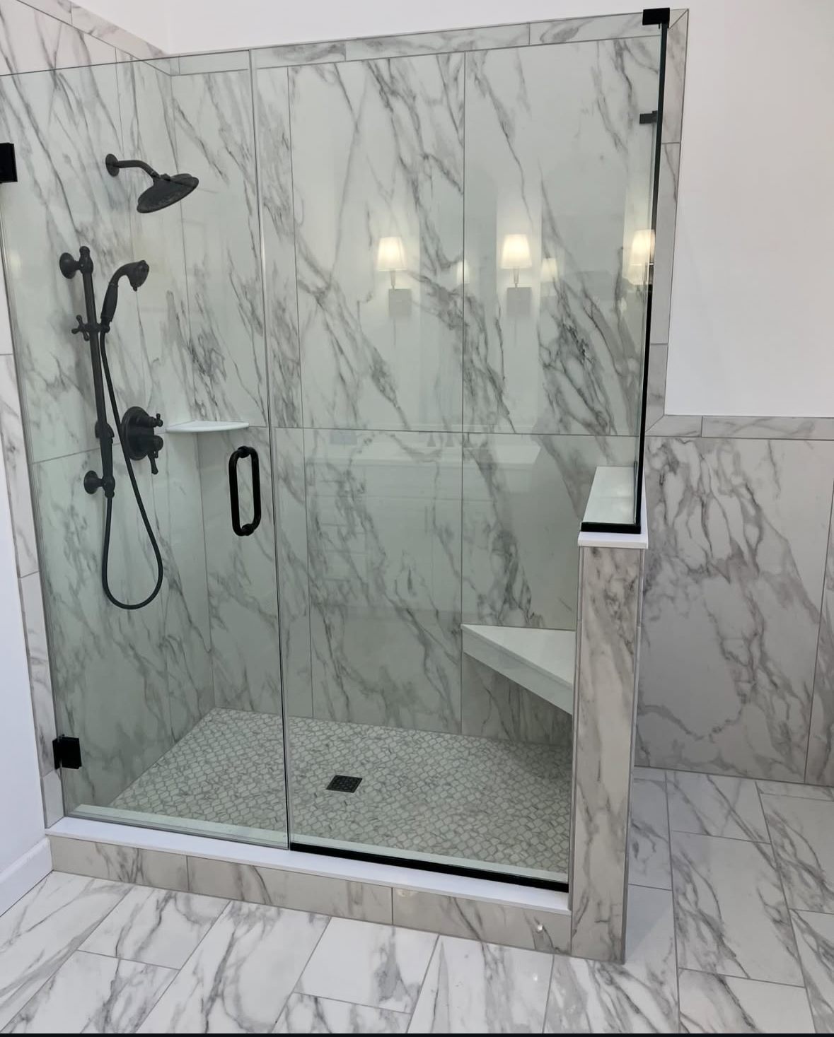 After: walk-in shower with marble-look walls, mosaic floor and glass enclosure